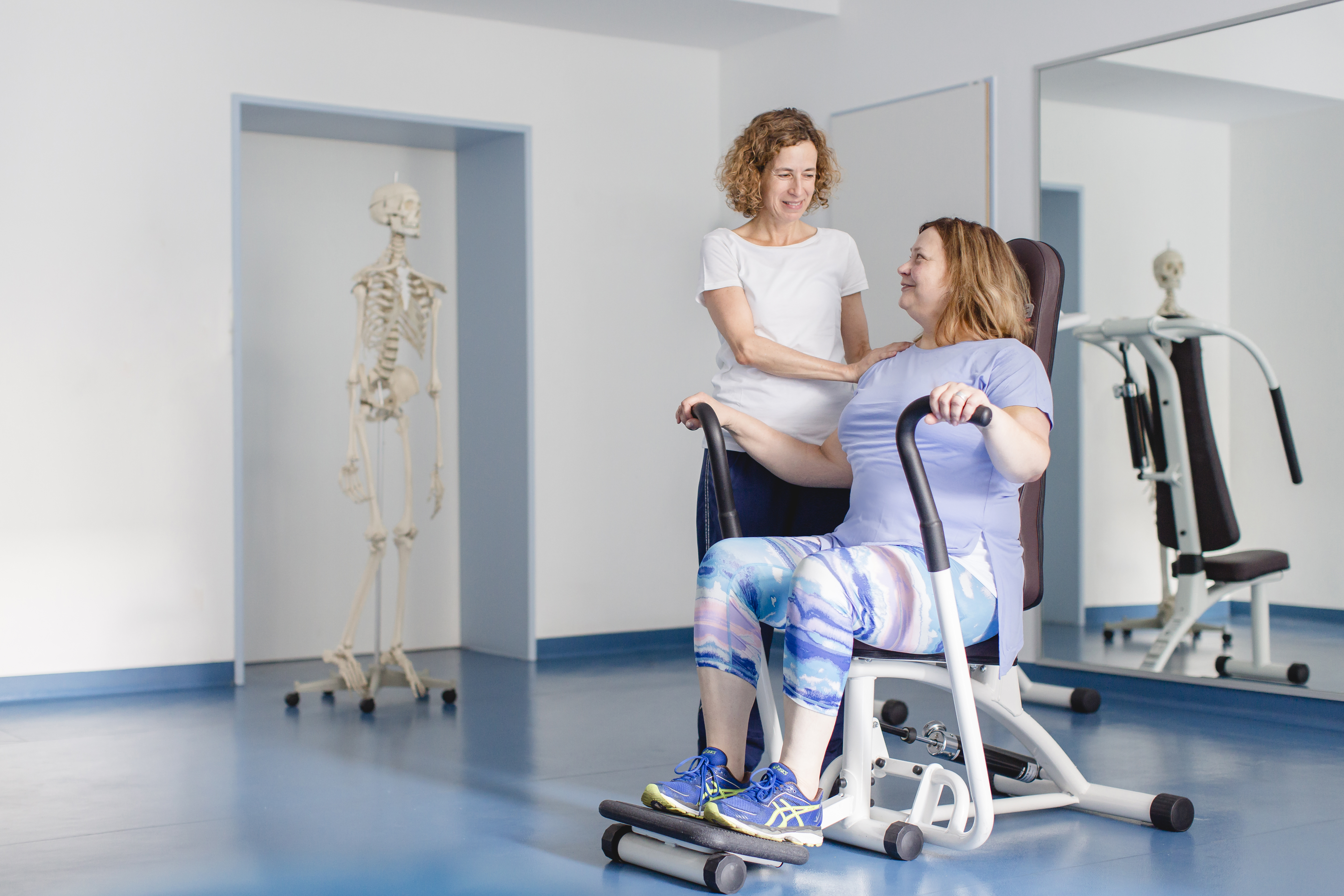 Eine Physiotherapiefachkraft unterstützt einen Patienten beim Training