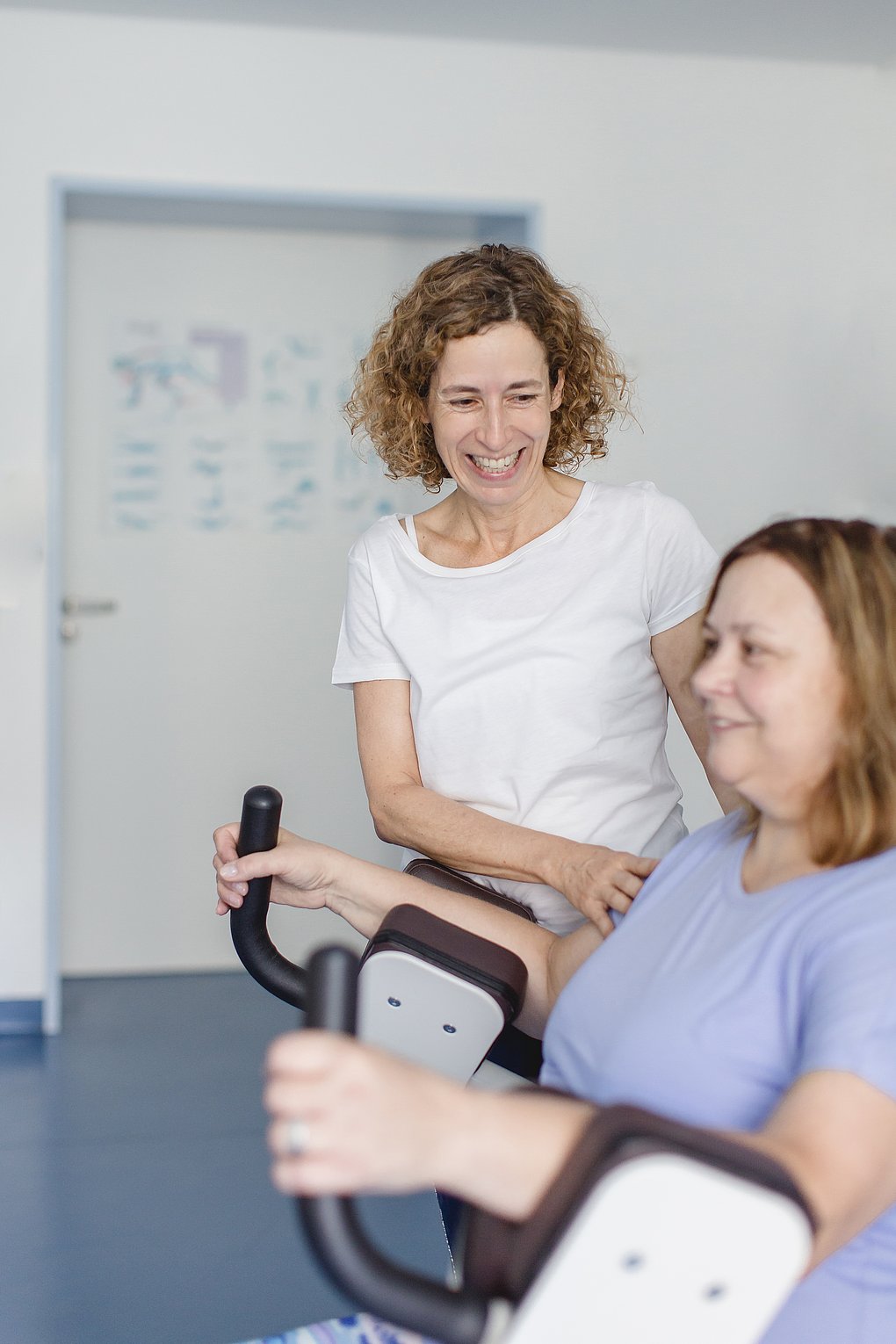 Eine Physiotherapiefachkraft unterstützt einen Patienten beim Training