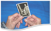 2 Hände einer älteren Person halten ein Kinderfoto